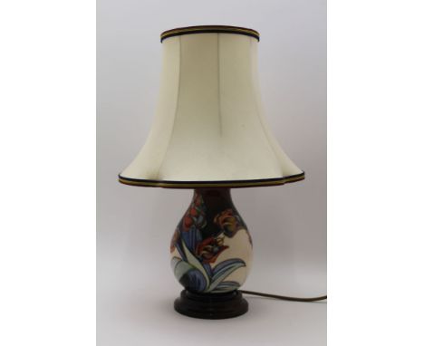 A MOORCROFT POTTERY TABLE LAMP of teardrop form, tube lined and painted tulip decoration on a cream ground, raised on a polis