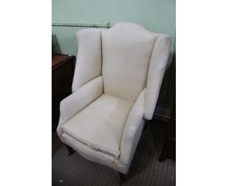 A GEORGIAN DESIGN WING BACKED ARMCHAIR all-over upholstered in old gold trellis pattern cotton, having feather filled squab c