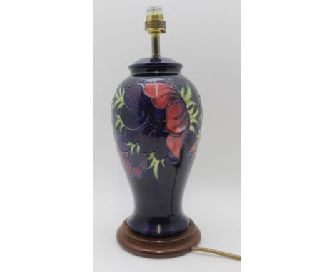 A MOORCROFT POTTERY TABLE LAMP of baluster form, tube lined and painted anemone decoration on a blue ground, raised upon a po