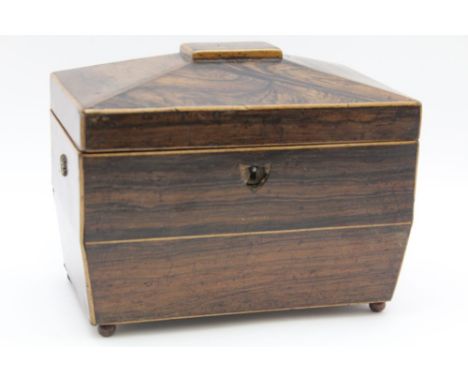 AN EARLY 19TH CENTURY REGENCY ROSEWOOD TEA CADDY, the hinged cover opens to reveal two inner lidded compartments, raised on b