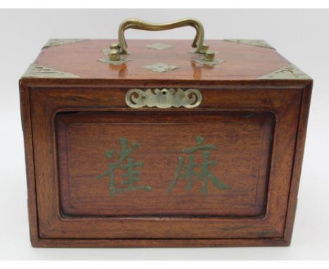 A CHINESE MAHJONG SET, in a polished hardwood chest with handles and decorative metal mounts, the slide at the front bears ch