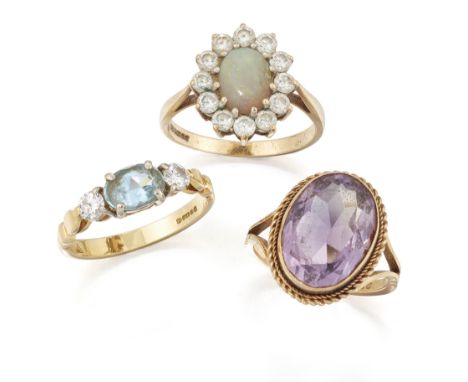 Three gold rings, comprising: an 18ct gold three stone aquamarine and diamond ring by Christopher Wharton, London hallmarks, 