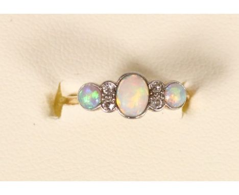 An Edwardian 18ct gold, opal and diamond threes stone ring, stamped 18ct, numbered 6851, milligrain collet set stones with si