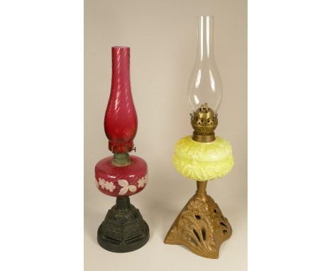 A 19th century cranberry glass oil lamp, on a gilt metal base, 52 cm, together with a vaseline glass oil lamp on a gilt metal