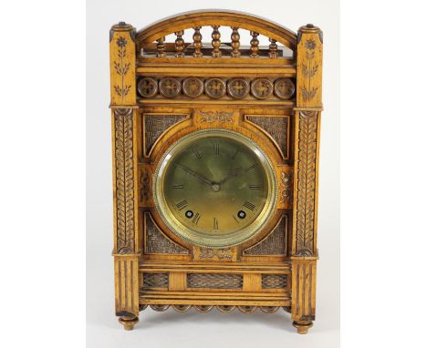 An Arts and Crafts mantle clock, brass dial with Roman numerals, the case with carved decoration, the movement striking on a 