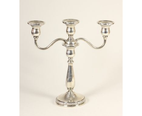 A silver two branch, three light candelabra, stamped STERLING, with baluster column, floral band to the base, 25cm, loaded. P