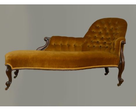 A Victorian mahogany chaise longue, with serpentine front, raised on cariole legs with brass casters, button upholstered in g