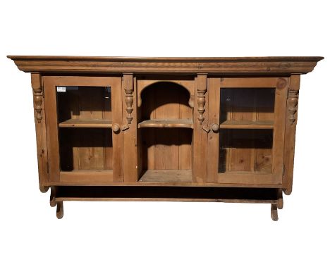 Pine wall shelf, the projecting cornice over two glazed doors, flanking one open shelfDimensions: Height:&nbsp;89cm&nbsp; Len