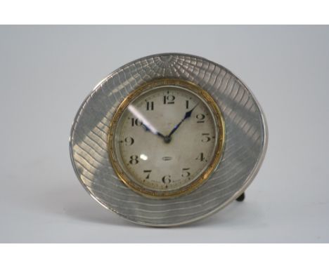 An Art Deco white metal cased eight day clock, with engine turned decoration, 8cm