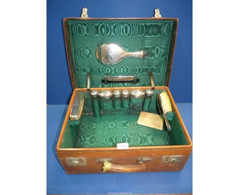A Ladies leather travel Case with beaten silver backed brushes, mirror and comb (a/f), silver topped jars, hallmarks for Lond