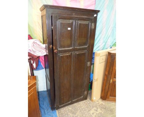 A dark Oak single Wardrobe/Cloaks Cupboard, the door having six raised and fielded panels, the interior with a hat shelf and 