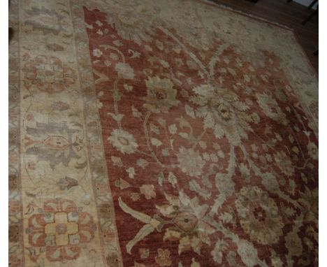 PERSIAN BORDERED CARPET WITH STYLIZED FLORAL PATTERN ON CLARET COLOURED GROUND. 422CM LONG X 303CM WIDE.