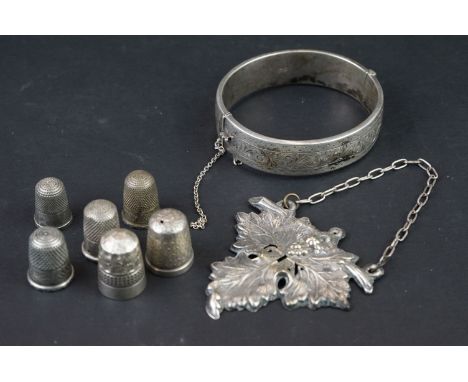 A collection of six hallmarked silver thimbles together with a hallmarked silver bangle and a white metal Gin decanter label.