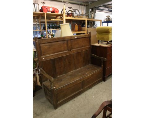 18th century Oak Panel Back Hall Bench / Settle with open arms, the seat with a hinged lid opening to a storage compartment, 