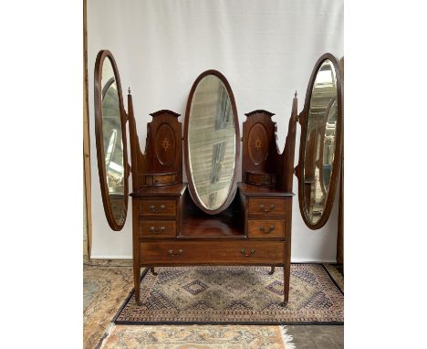 A Late Victorian/ early Edwardian five drawer dressing table chest, Designed with centre mirror off set by to large mirrors. 