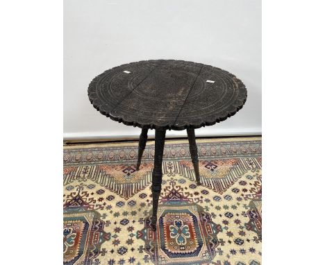 A hand carved hardwood oriental table, upon a tripod leg [height 48cm, diameter, 43cm] 