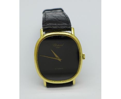 An 18ct gold cased Chopard automatic dress wristwatch with black dial, on a leather Patek Philippe strap with a gold plated c