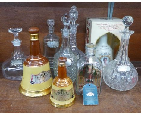 A Holmegaard glass Christmas bottle, a commemorative Bell's Scotch Whisky decanter with contents, four glass decanters, a sil