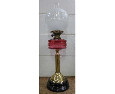 A table lamp with cranberry glass reservoir and glass shade, 72cm