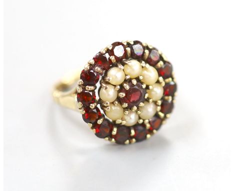   A modern 9ct gold, garnet and split pearl set circular cluster ring, size M, 5 grams.