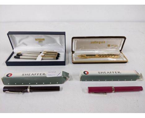 A mixed lot to include a boxed Ronson Racer collection ballpoint, Rollerball and fountain pen set, along with a boxed gold co