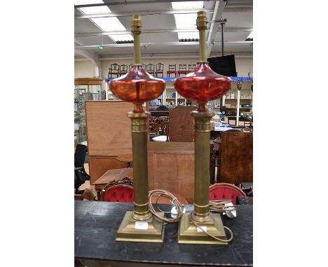 A pair of brass column with ruby glass middle table lamps