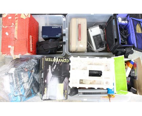 A large collection of photographic equipment including projector with films on wheels, slide projector