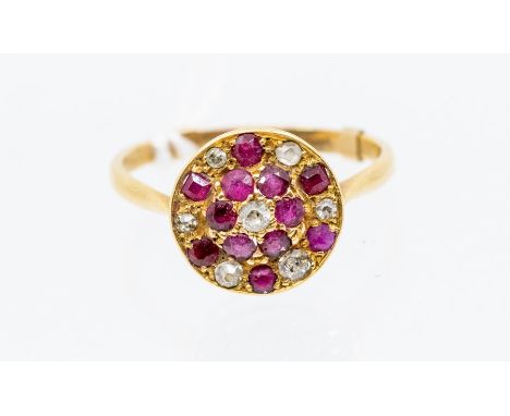 An early 20th Century ruby and diamond set 18ct gold  ring, comprising a circular disc grain set with alternate round cut rub