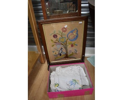 A vintage oak framed fire screen, the panel embroidered with flowers, tree and bird together with embroidered table cloth, an