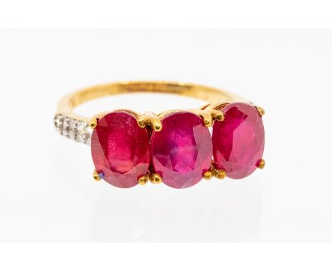 A ruby and diamond 9ct white gold ring, comprising three oval cut claw set rubies, total ruby weight  approx 6carats, with sm