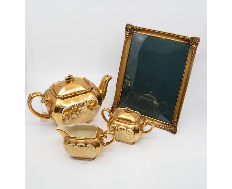 Gold ceramic teapot, milk and sugar, probably Sadler, mirror, and a 19th Century cushion glass photograph frame