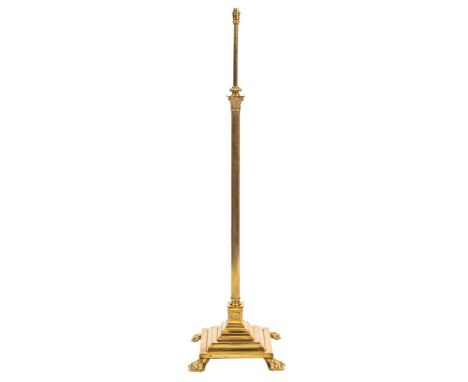 A brass columnar standard lamp, first quarter 20th century,: the electrical fitment on a telescopic stem rising from a Compos