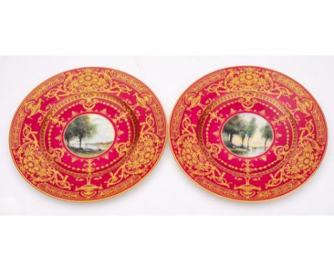 A pair of Royal Worcester porcelain plates: the centres painted with a circular panel decorated with figures in a landscape b