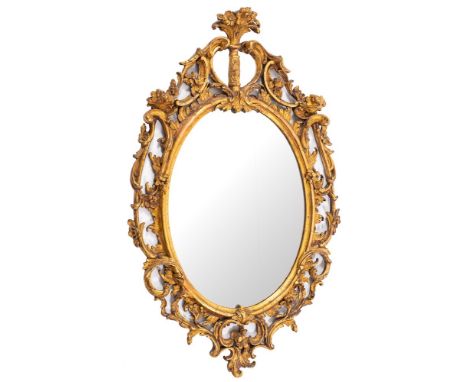 A giltwood and composition framed oval wall mirror in Rococo style, second half 18th century,: the openwork surround with flo