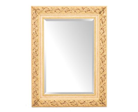 A wood and parcel gilt composition framed rectangular wall mirror, of recent manufacture,: the cushion surround modelled with