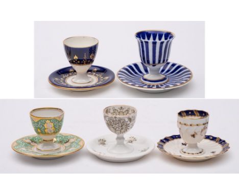 A group of five egg cups on integral stands: including a Chamberlains Worcester cup with blue banded decoration, circa 1840-5