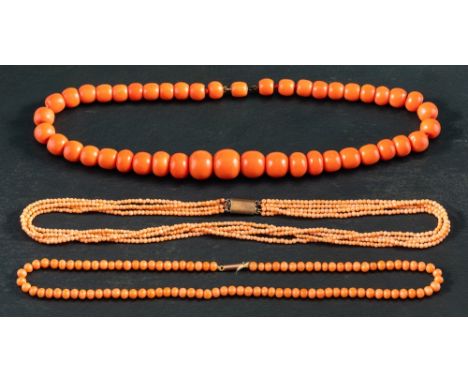Three coral necklaces,: one single row of graduated deep pinkish orange beads, diameter ca. 8.2-14.6mms, length ca. 39.5cms; 