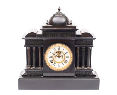 An American black slate mantel clock: the eight-day duration movement striking the hours on a gong, the cream enamel dial wit