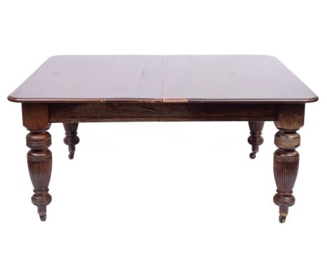A Victorian mahogany extending table, late 19th century,: the top with moulded edges, above a screw action; on lobed and reed