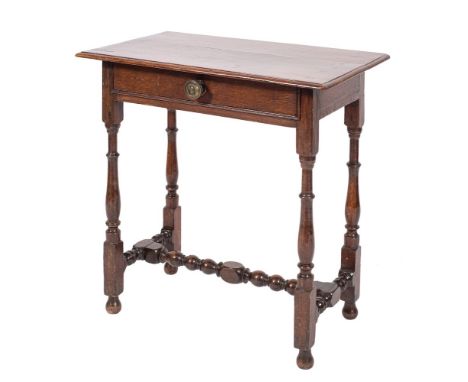 An oak side table in 17th century style, late 19th century,: the rectangular top with moulded front and side edges, above a f