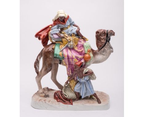 A large Royal Dux Bohemia porcelain group: modelled as an Arab atop a camel with a young lad with carpet bags at his foot, on