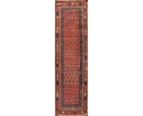 A Caucasian runner:, the rose field with an all over geometric boteh design, enclosed by a main shaded wine serrated medallio