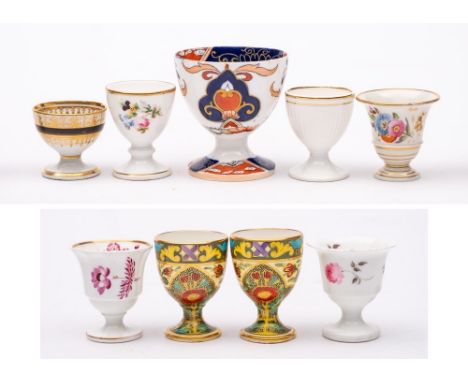 A group of nine egg cups: including a Chamberlains Worcester gilt and black decorated cup, circa 1800; a pair of Minton cups 