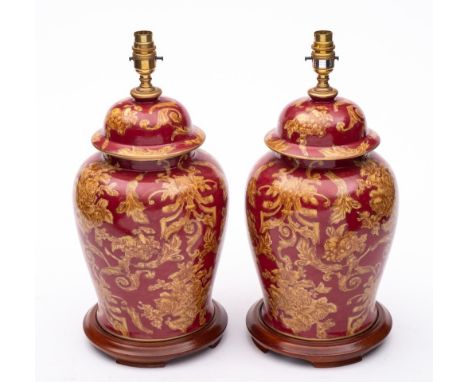 A pair of modern ceramic table lamps: decorated with scrolling flowers and foliage on a claret ground, 60cm including fitting