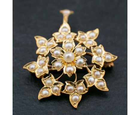 An 18ct gold, Victorian, seed pearl brooch/ pendant of stylised floral design,: length ca. 3.9cm, total weight ca. 5.1gms.  