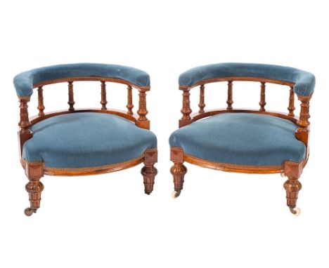 A pair of Victorian mahogany and upholstered low tub armchairs, circa 1870,: the padded hoop toprails on turned spindle suppo