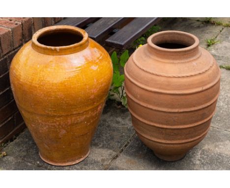 Two Continental terracotta garden urns/olive jars:, of ovoid form, one glazed, 57cm and 56cm high respectively.