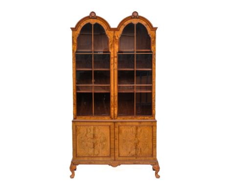 A walnut and crossbanded double arch topped cabinet bookcase in Queen Anne style, 20th century,: the moulded cornice with twi