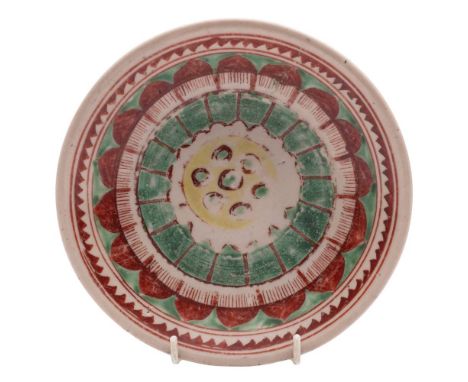 A Chinese Swatow ware deep plate: painted in iron-red, green and yellow with a flower head medallion within lotus and geometr