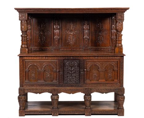 A carved oak court cupboard or duodarn, elements possibly early 17th century and later,: the canopy with projecting cornice a